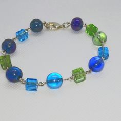 Multicolor Beaded Silver Adjustable Blue-green Beaded Jewelry, Multicolor Czech Glass Bracelet With Spacer Beads, Multicolor Czech Glass Crystal Bracelet With Spacer Beads, Iridescent Beaded Bracelets With Colorful Beads, Multicolor Czech Glass Bracelets For Party, Party Multicolor Czech Glass Bracelets, Multicolor Glass Crystal Bracelet With Faceted Beads, Colorful Czech Glass Beaded Bracelets For Parties, Multicolor Czech Glass Beaded Chain Bracelets