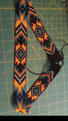 a colorful beaded tie sitting on top of a cutting board