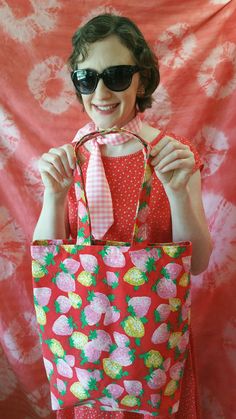 "This cheerful tote is a celebration of vintage fabric and a love of color! The vibrant strawberry print features bright pink and yellow strawberries, mint-green leaves, and a tomato-red background. Great as a casual shoulder bag, summer carry-all, mid-weight shopping bag, and unique gift. Heavy-weight, vintage cotton used in bag exterior and lining. Dimensions: Approximately 15.5\" inches tall, 14.5\" long, 3.5\" wide. Hand wash, line dry. Handmade with love in the heart of hippy country, USA!" Yellow Strawberries, Friendship Earrings, Bag Summer, Strawberry Fields, Strawberry Print, Fabric Gift Bags, Blue Gingham, Pink And Yellow, Fabric Gifts