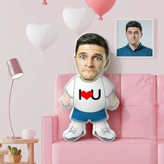 a man is sitting on a pink couch with balloons in the shape of heart shapes