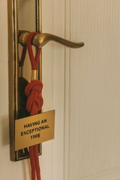 a red rope attached to a door handle with a sign saying having an exceptional time