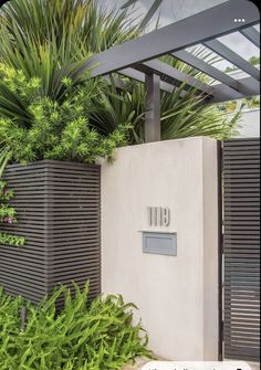 the entrance to an apartment building with plants growing on it's sides and a mailbox