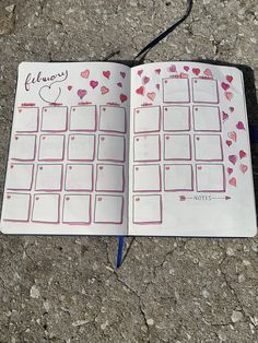 an open planner with hearts on it sitting on the ground next to a blue marker