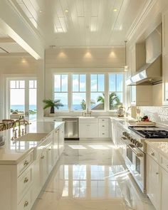 a large kitchen with white cabinets and marble counter tops