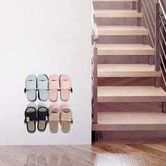 there are four pairs of slippers hanging on the wall next to each other in front of stairs