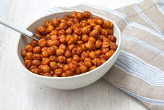 a white bowl filled with chickpeas on top of a blue and white towel