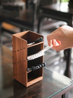 a person is holding a knife in a wooden holder