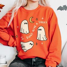 Retro Halloween Ghost Sweatshirt, Funny Boo Ghost Fall Jumper, Cute Ghost Sweater, Trick or Treat Costume, Spooky Season Outfit, UNISEX  Who can resist this aesthetic retro fall themed Halloween Sweatshirt? The illustration on the sweatshirt features 3 ghosts floating around and the funny quote reads 'I don't give a sheet'.  It's comfy and soft make makes a perfect gift for a loved one, or for anyone who is a fan of the grungy vintage autumn aesthetic. This cute sweatshirt is available in multip Spooky Orange Long Sleeve Tops, Orange Long Sleeve Spooky Top, Spooky Long-sleeve Orange T-shirt, Spooky Long Sleeve Orange T-shirt, Spooky Orange Long Sleeve T-shirt, Orange Crew Neck Halloween Sweatshirt, Vintage Autumn Aesthetic, 3 Ghosts, Ghost Sweater