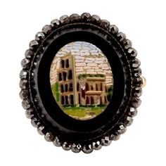 This micro mosaic is from the 1870’s or 80's and is in excellent condition for its age. The tablet is set with a beautiful halo of tiny silver alloy faceted pieces made to emulate diamonds around it. It measures 17.5 mm x 20 mm. The metal faceted gems are set in a low grade gold, from the backside you can see the labor that went into crafting this surround. The micro mosaic of the Coliseum was made using a painstaking technique that involves creating an image out of small pieces of opaque enamel Mosaic Ring, The Coliseum, Faceted Gems, Micro Mosaic, Grand Tour, Cocktail Rings, Labor, Halo, Vintage Jewelry