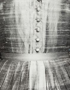 a black and white photo of a woman's dress with buttons on the back