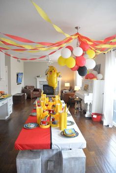 a long table with balloons and plates on it