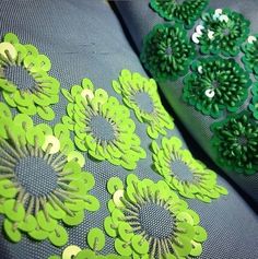 green flowers are on the back of a pair of blue and gray shoes with sequins