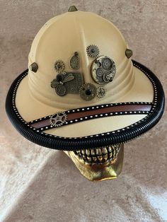 This hat is a costume-quality hat with fabric over something light (plastic? Foam?).    It has an elastic sweatband and ranges 55-58 cm.  It fits my oval 22 inch head fine.   Can be remade on request, though the fittings will vary with materials.   The hat is embellished with a variety of metal gears, studs, etc., with corrugated piping around the edge. More hats available at tricornes.shop without added ETSY fees. Adjustable Novelty Mini Hat For Cosplay, Steampunk Adjustable Hat For Costume Party, Steampunk Adjustable Costume Hats And Headpieces, Vintage Adjustable Costume Hats And Headpieces For Party, Vintage Adjustable Costume Hat For Costume Party, Steampunk Adjustable Masks And Prosthetics For Festivals, Adjustable Brimmed Themed Costume Accessories, Vintage Short Brim Costume Hats For Themed Events, Adjustable Steampunk Masks And Prosthetics For Festival