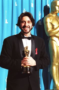 a man in a tuxedo holding an award