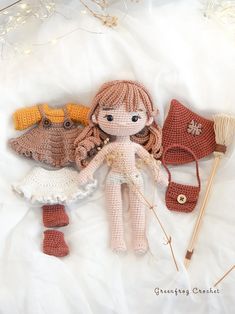 three crocheted dolls laying next to each other on a white sheet with knitting needles