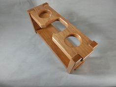 a wooden object with holes in it sitting on a table next to a white background