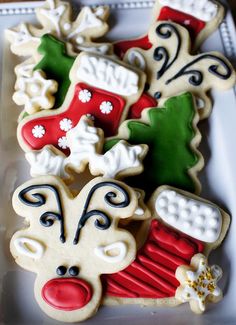 decorated cookies in the shape of santa's stocking boots and stockings on a plate