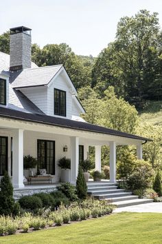 a white house with black shutters on the front porch and steps leading up to it