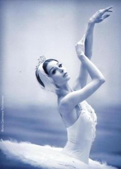 a black and white photo of a ballerina wearing a tiara with her arms in the air