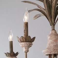 an old chandelier with two candle holders and one pineapple on the top