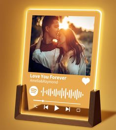 an illuminated photo frame with the words love you forever on it and a music player next to it