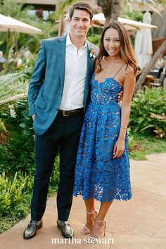 a man standing next to a woman in a blue dress