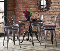 a dining room table with chairs and a vase filled with flowers on top of it