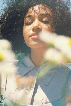 a close up of a person wearing a shirt and flowers in front of her face