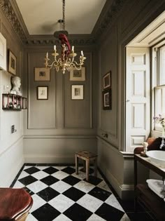 a bathroom with a checkered floor and chandelier hanging from the ceiling next to a window