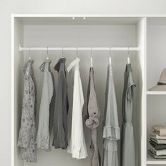 an open closet with clothes hanging on hooks