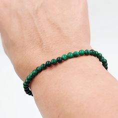 Malachite Bead Bracelet Experience the striking beauty of our Malachite Bead Bracelet, featuring 8mm beads. Malachite is known for its vibrant green hues and distinctive banded patterns, making this bracelet a stunning accessory for any outfit. Each bead is meticulously polished to reveal the stone's natural beauty, creating a bracelet that exudes elegance and sophistication. Harness the Power of Transformation Malachite is celebrated for its powerful transformative and protective energies. Often referred to as the "stone of transformation," malachite helps clear away negative energy and supports emotional healing and growth. Wearing this bracelet can help you harness these transformative powers, bringing balance and positive change into your life. A Gift of Strength and Beauty Our Malachi Green Bracelets With Natural Stones In Round Beads, Green Bracelets With Natural Stones And Round Beads, Green Natural Stone Beaded Bracelets, Green Gemstone Beads Bracelet, Spiritual Green Stretch Bracelet With Polished Beads, Green Bracelets With Spacer Beads, Green Stretch Bracelet With Round Beads In Spiritual Style, Green Spiritual Bracelet With Spacer Beads, Green Stretch Bracelet With Polished Beads