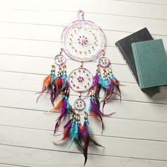 a colorful dream catcher sitting on top of a table next to a book and pen