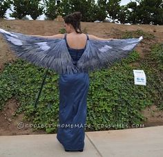 a woman in a blue dress with wings on her back