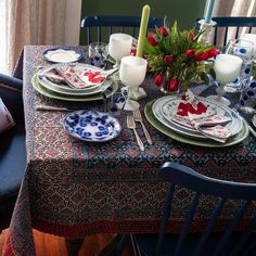 the table is set with plates, silverware and candles