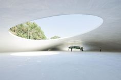 people are standing in the middle of an empty room with white walls and ceilinging