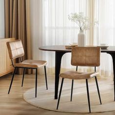 a dining room table with two chairs and a vase on top of it in front of a window