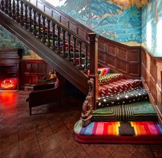 a stair case next to a set of stairs in a room with colorful rugs on the floor