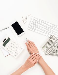 a person holding a cell phone next to a notebook