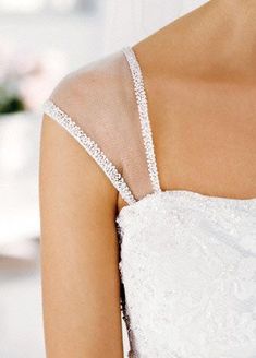 the back of a woman's wedding dress with beading on her shoulders and shoulder