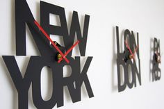 three black and red wall clocks on a white wall with the words new york written across them