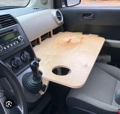 the interior of a small car with a wooden table in the front and center console