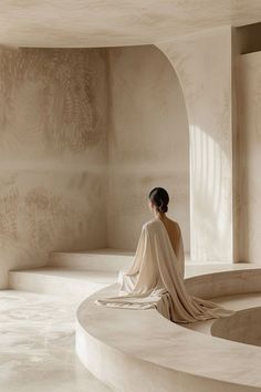 a woman sitting on top of a white bench