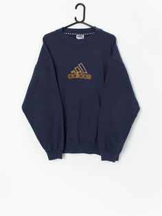 Vintage Adidas jumper in navy and yellow. This classic navy blue Y2K jumper features the Adidas trefoil embroidered logo on the chest in yellow and white. Made from a mid-weight cotton and polyester blend. Made for men but can be a great Y2K fit for everyone! Our recommended size: Large Label says: GB 38-40, US M Condition: Very good Material: 70% cotton, 30% polyester Measurements in inches: Pit to pit: 25 Shoulders: 24 Front length: 27 Back length: 27.5 Sleeve length: 23 Hem unstretched: 18.5 Y2k Jumper, Adidas Jumper, Vintage Adidas Sweatshirt, Y2k Sweatshirt, Navy And Yellow, Blue Y2k, Pullover Sweater Men, White Jumper, Adidas Trefoil