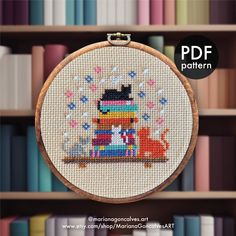 the cross stitch pattern is on display in front of bookshelves with colorful books