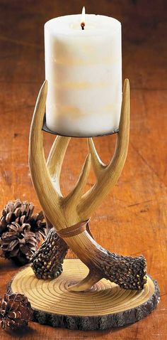 the antler candle holder is made out of wood and has a white candle in it