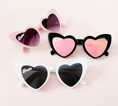 three pairs of heart shaped sunglasses sitting on top of each other