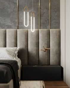 a modern bedroom with grey walls and gold lighting fixtures on the headboard, along with an upholstered bed