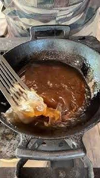 a fork is being used to stir food in a pan on an open stove top