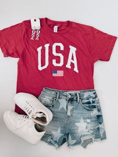 Celebrate your love for the USA with our USA Flag Graphic Tee! Made of super soft material, this unisex tee features a bold USA screen print. Show off your patriotic pride in style and comfort. Available in sizes S-2XL. Graphic Tee Dress, Swim Shop, Top Graphic Tees, Glitz And Glam, Tee Dress, Red And Grey, Gift Accessories, Dress Romper, Usa Flag