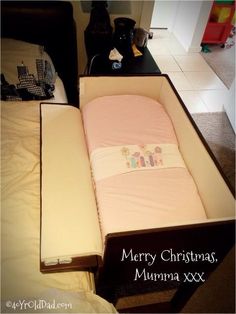 a baby's crib in the middle of a bed with a merry christmas message on it